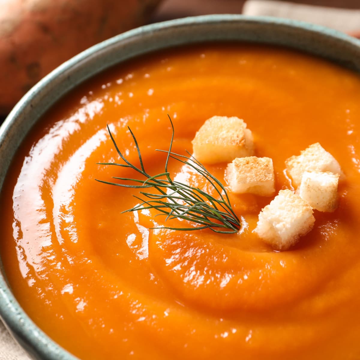 Tasty Sweet Potato Soup With Bread Slices and Herbs Garnish