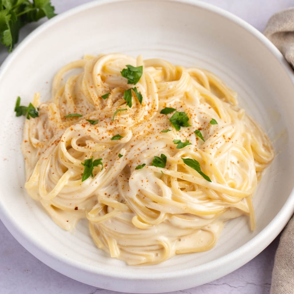 Creamy Homemade Noodles Romanoff with Herbs Served on a Plate