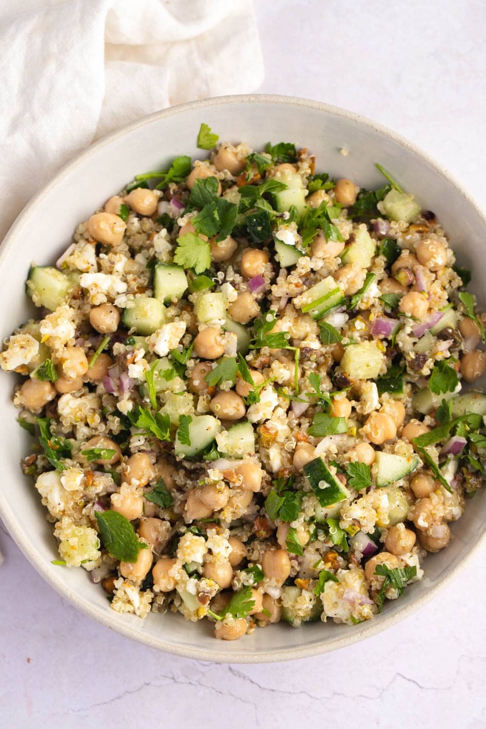 Jennifer Aniston Salad in a bowl made with quinoa, sliced cucumber, herbs and spices