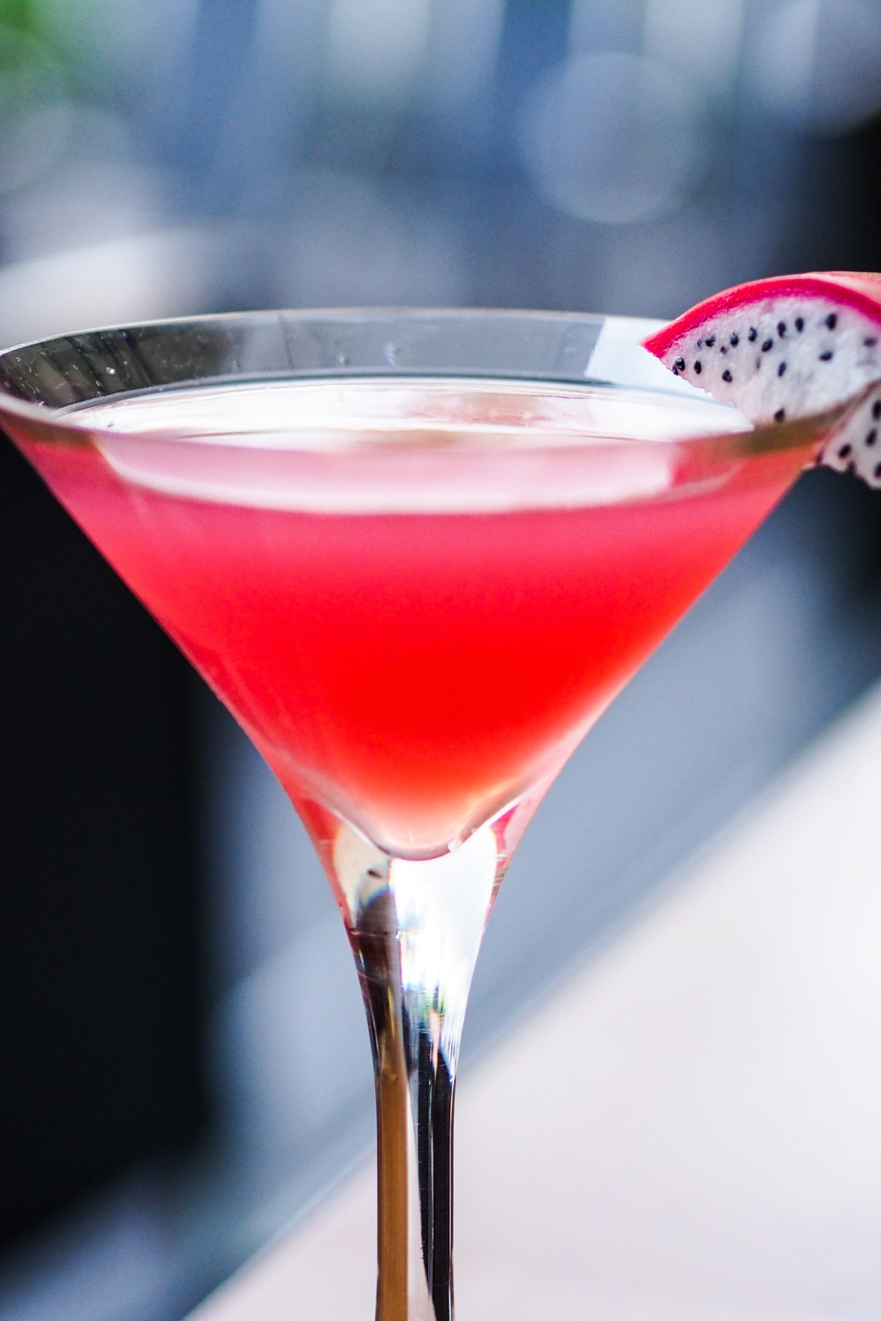 A Glass of Pink Dragon Fruit Cocktail Garnished With a Slice of Dragon Fruit