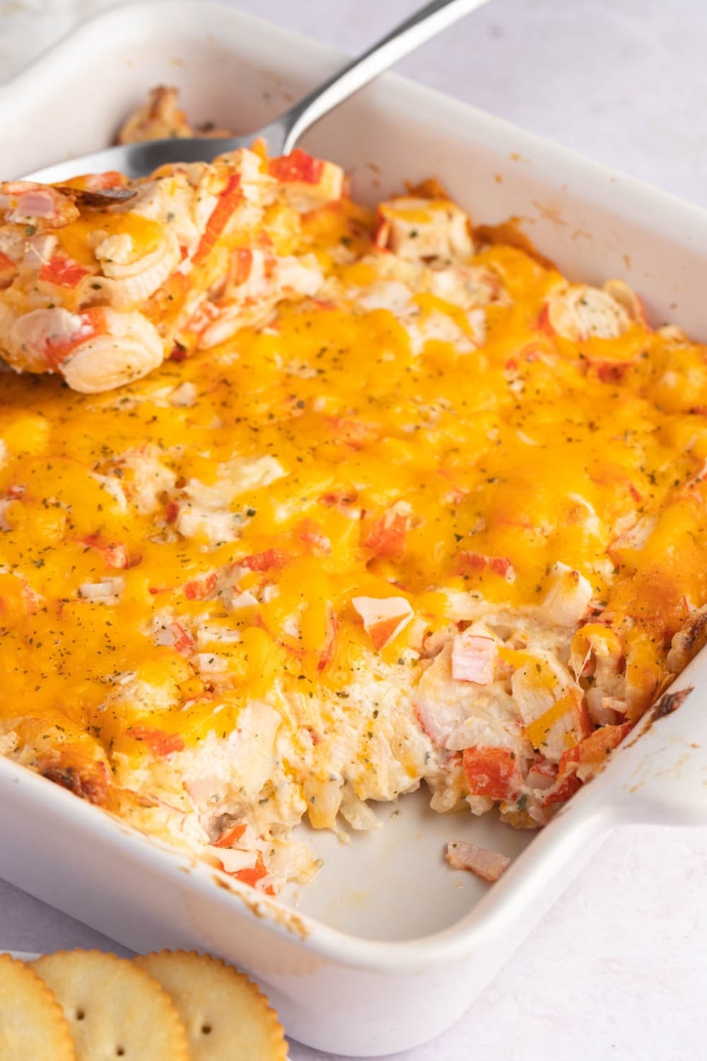 Crab meat, onion, spices, cheese, cream cheese, mayo, and sour cream baked on a casserole served with crackers on the side