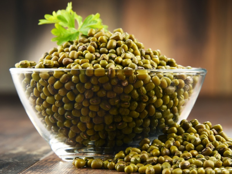 Mung Beans on a Clear Glass Bowl and Some Portions on the Table 