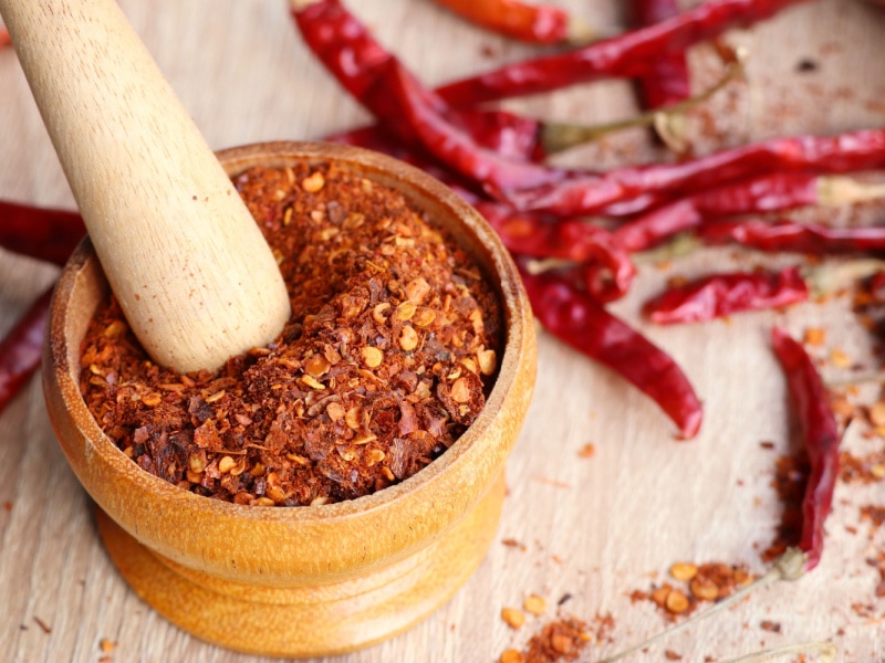 Dried Cayenne Pepper Powdered Using a Wooden Mortar and Pestle