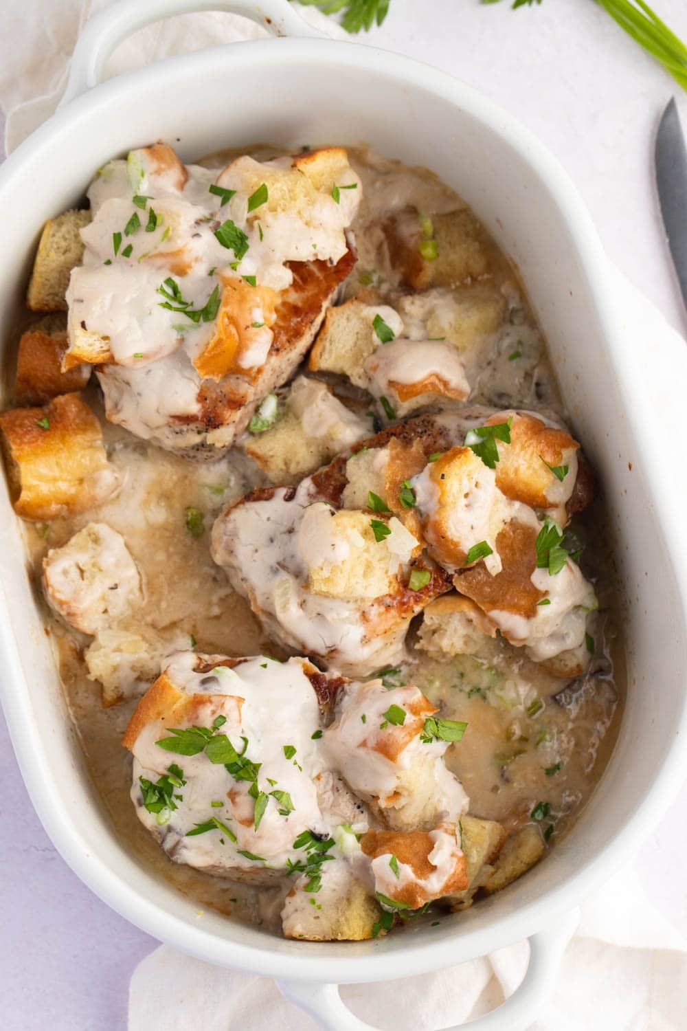 Baked Pork Chops with Cream Sauce and Stuffing, Garnished With Chopped Celery and Onions