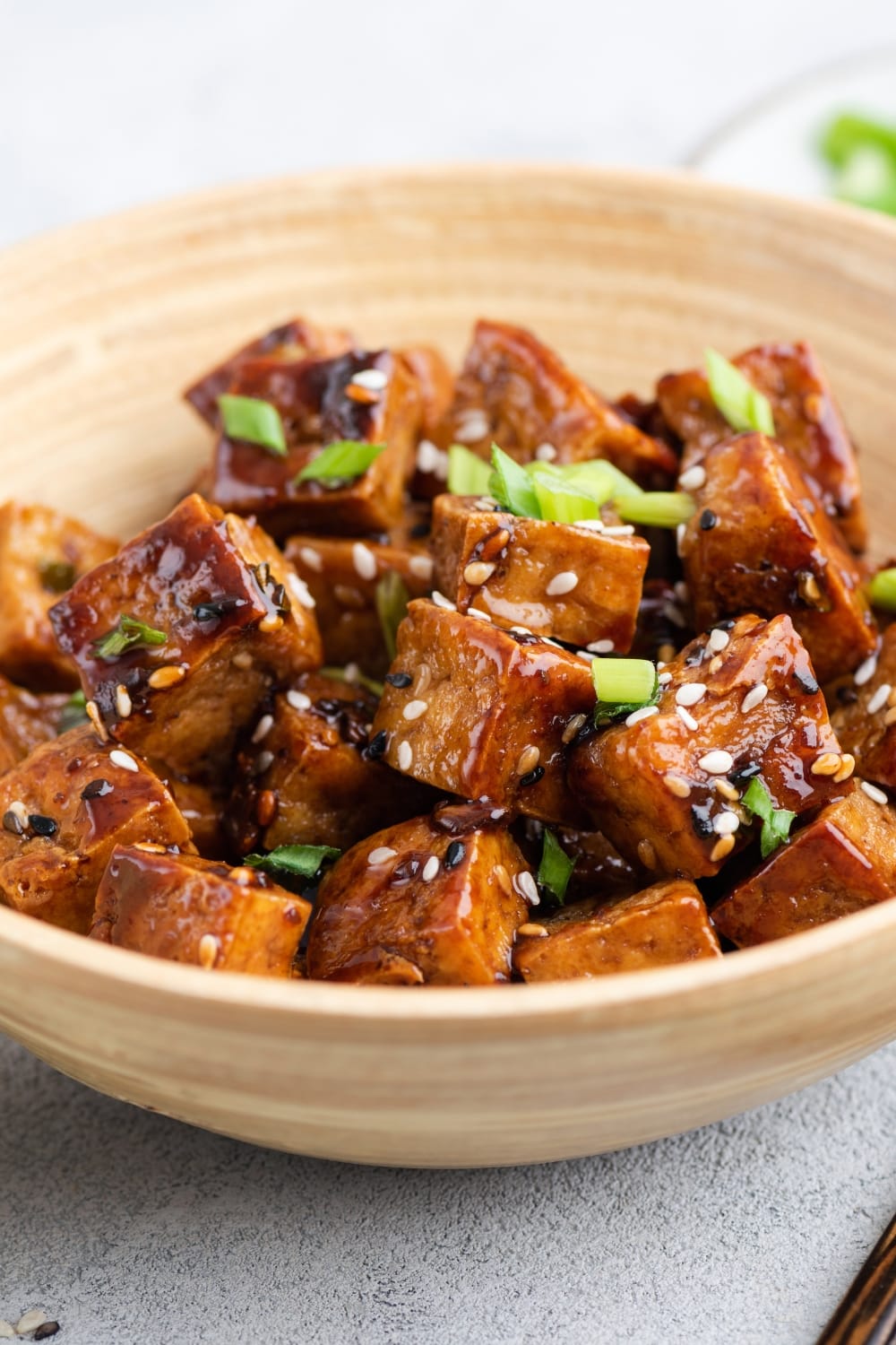 Tofu Cubes with Teriyaki Dipping Sauce and Sesame Seeds, Served on a Brown Bowl