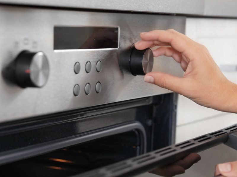 Woman Regulating Oven Temperature