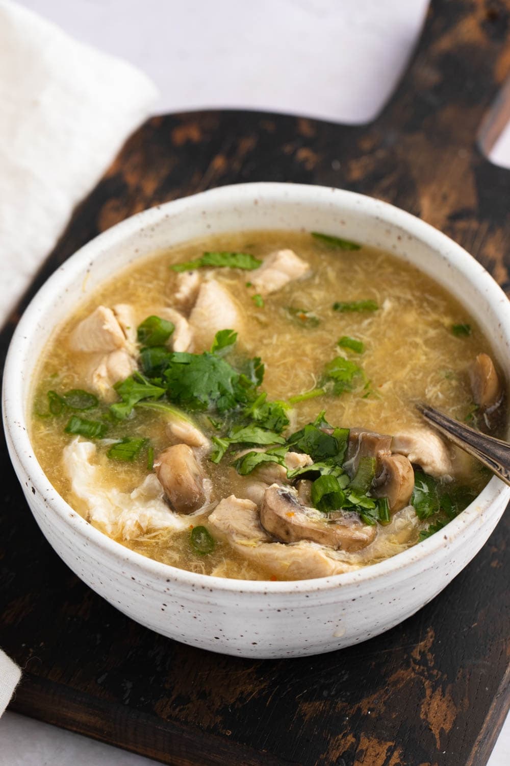 Bowl of Hot and Sour Chicken with Mushroom and Chopped Parsley Leaves