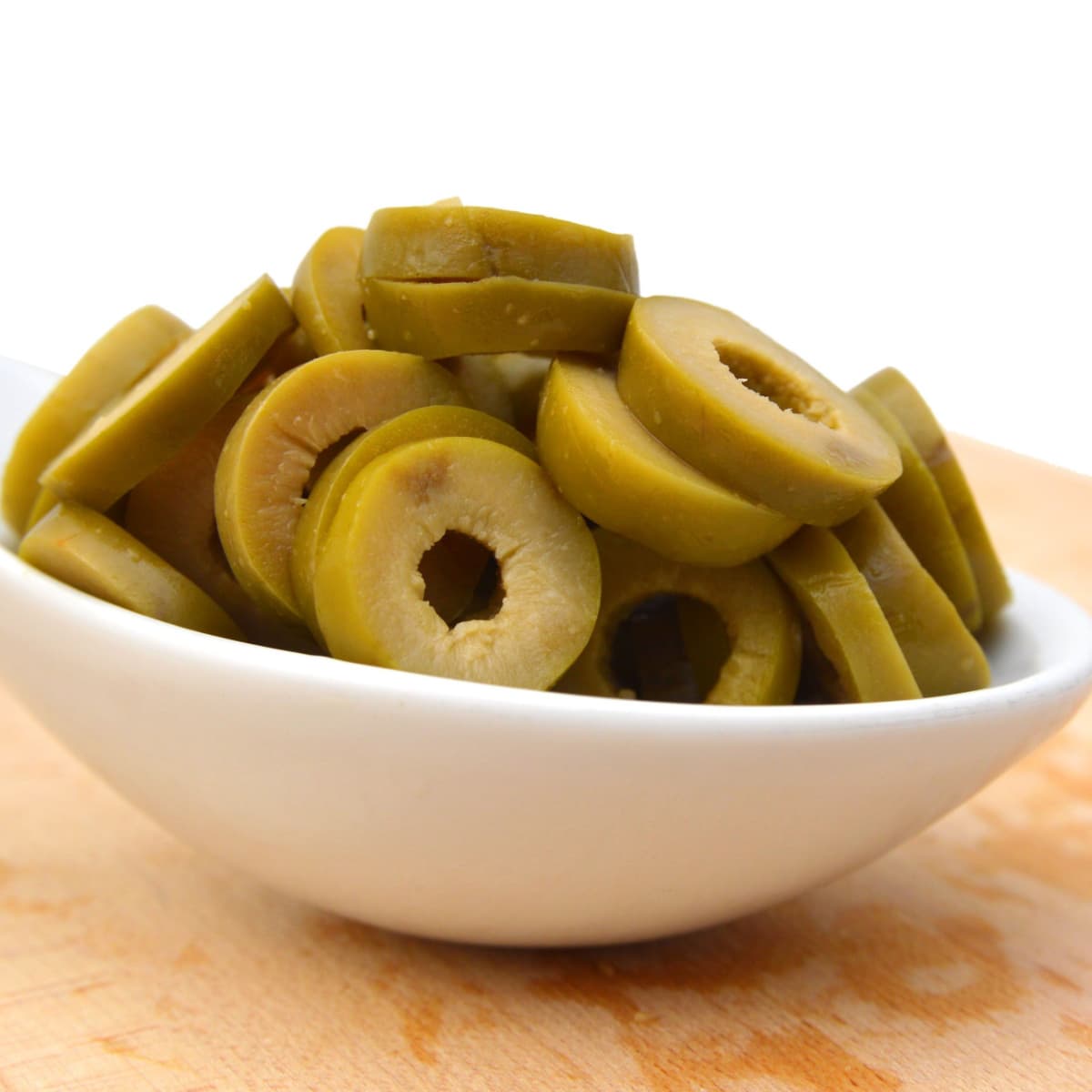 Chopped Green Olives in a White Measuring Spoon