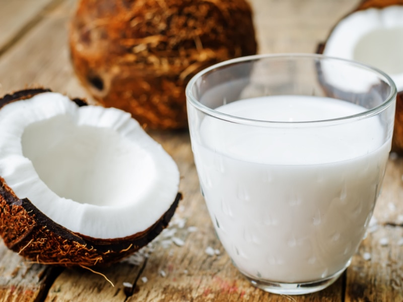 Half a coconut and a glass of coconut milk