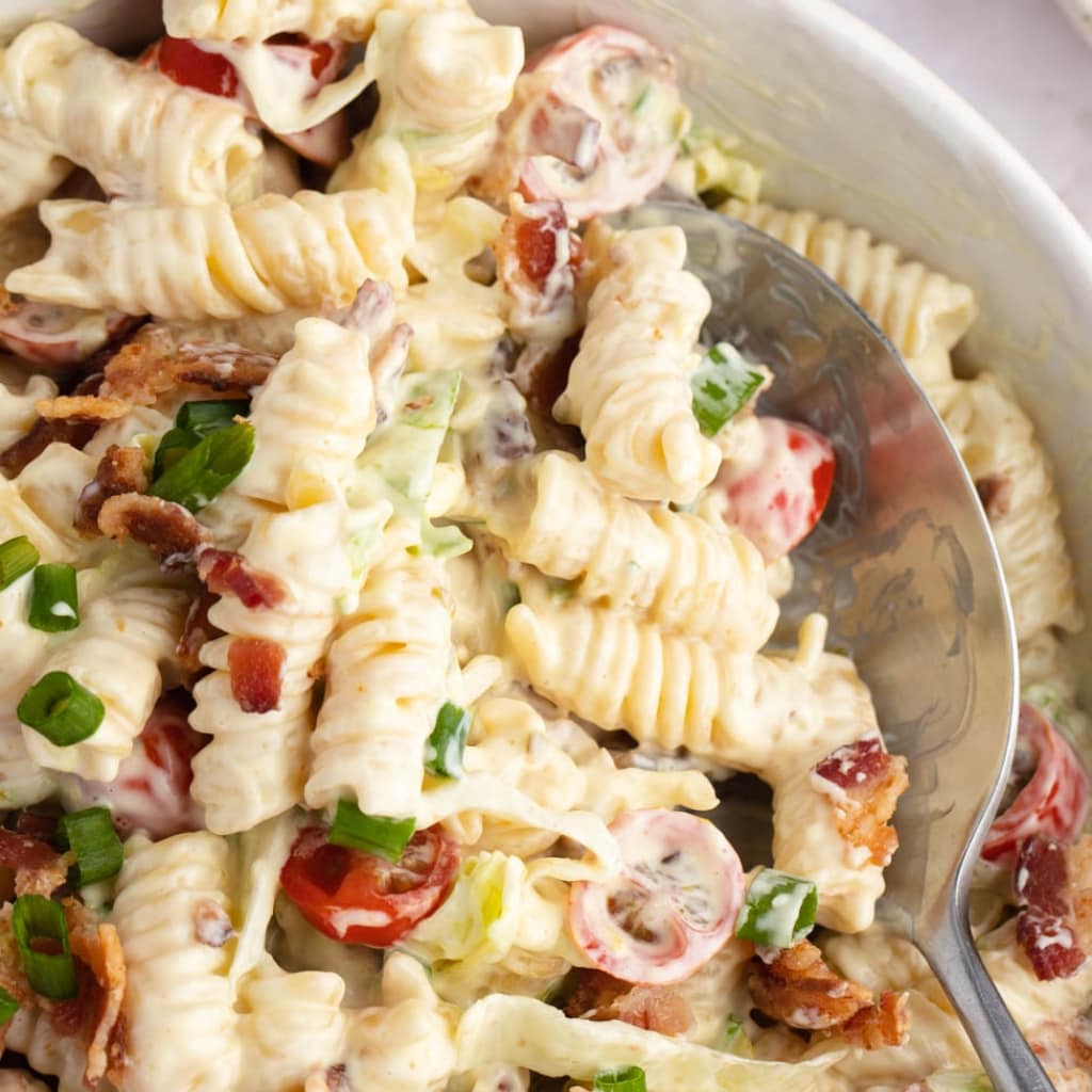 Spoon Scooping Creamy BLT Pasta Salad with Bacon, Scallions, Tomatoes and Lettuce