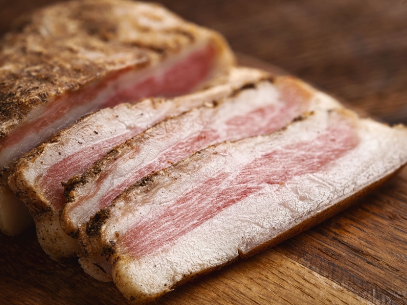 Guanciale Pork Slices on a Wooden Chopping Board