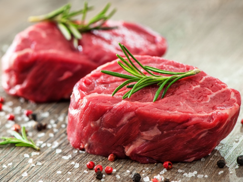 Raw Filet Mignon with Herbs and Spices on a Wooden Table