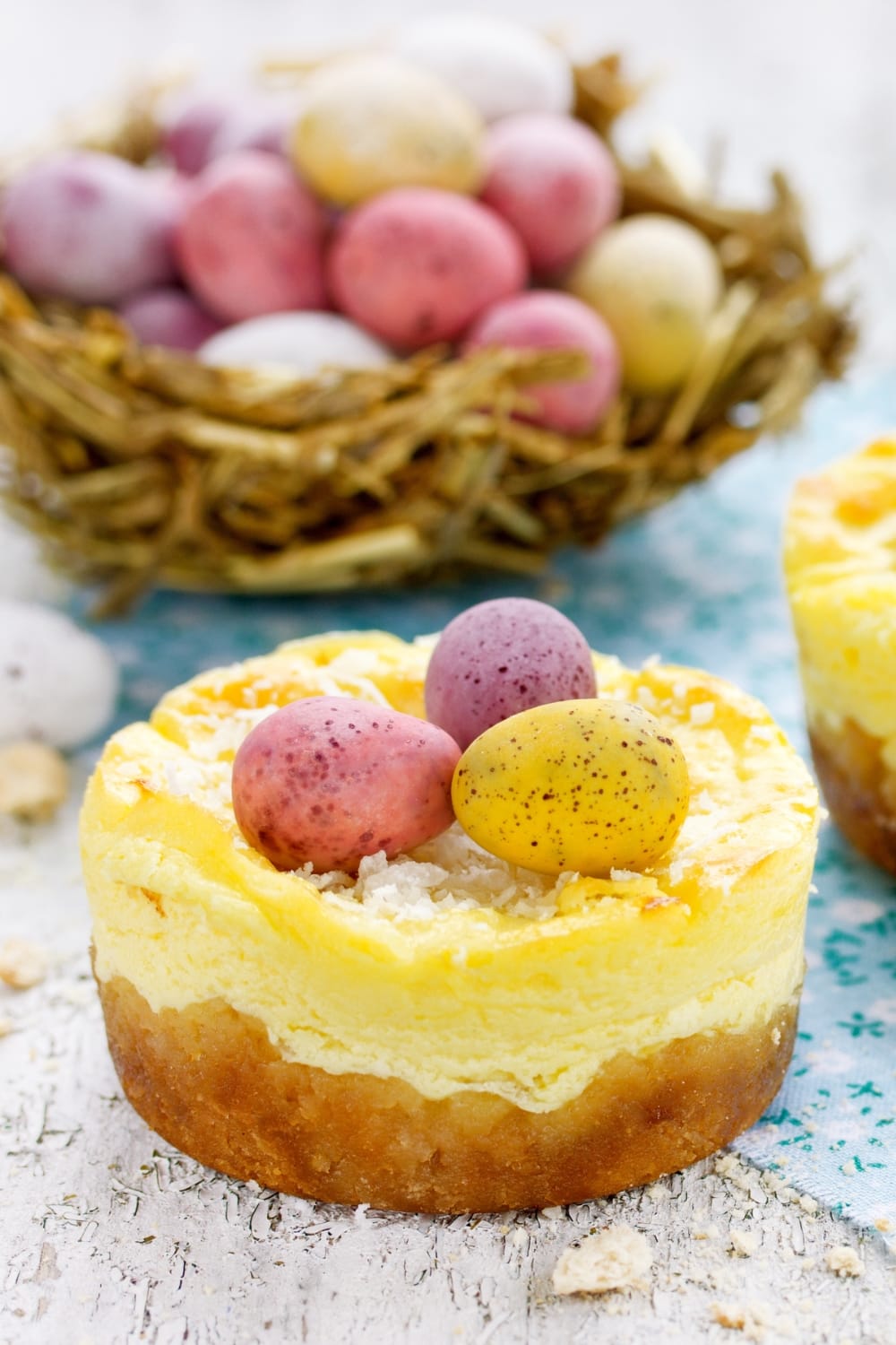 Mini Easter Cheesecake Nests Made of Layered Pudding and Cheesecake, Topped with Egg Shaped Stone Candies