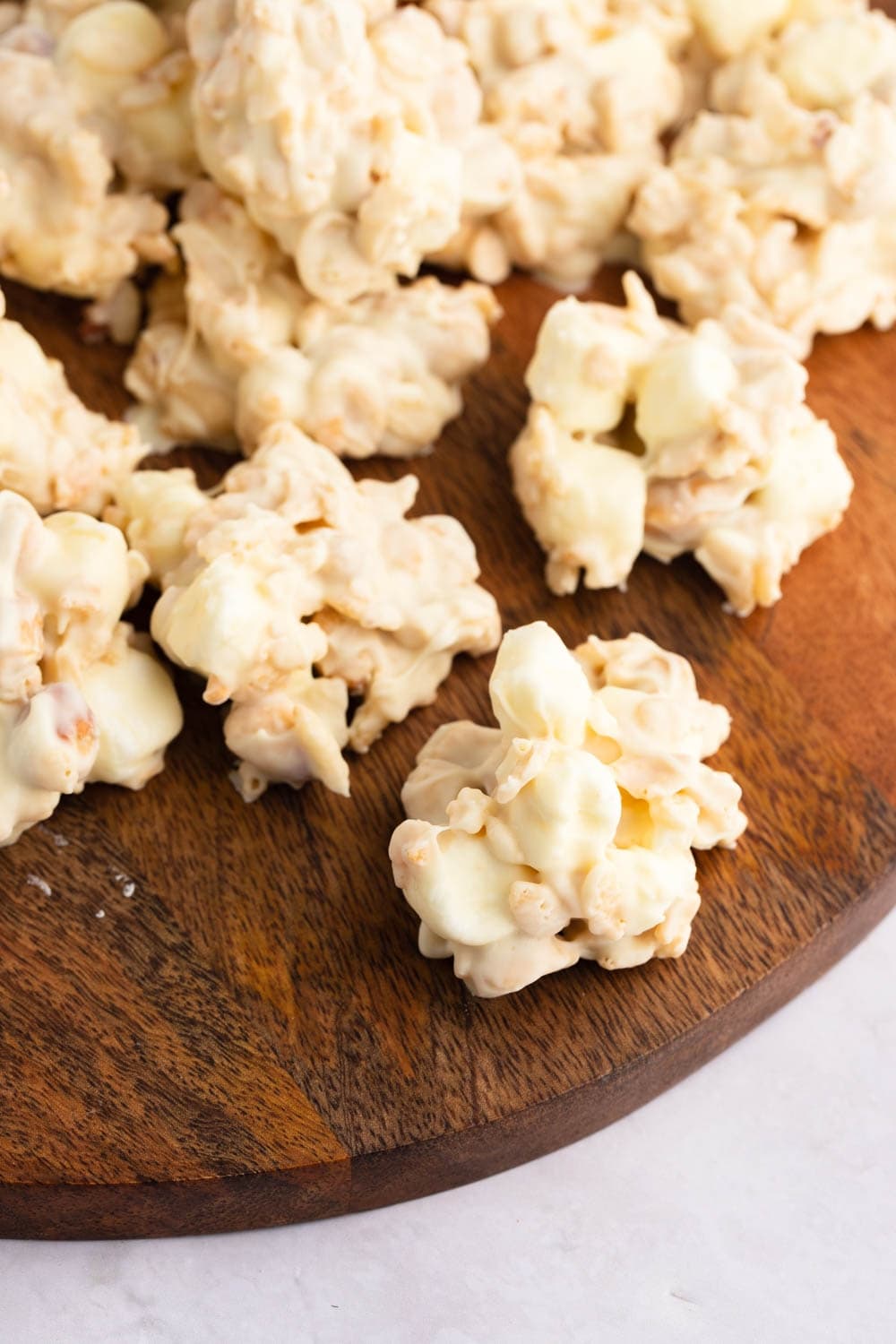 White chocolate covered Rice Krispies on a wooden cutting board. 