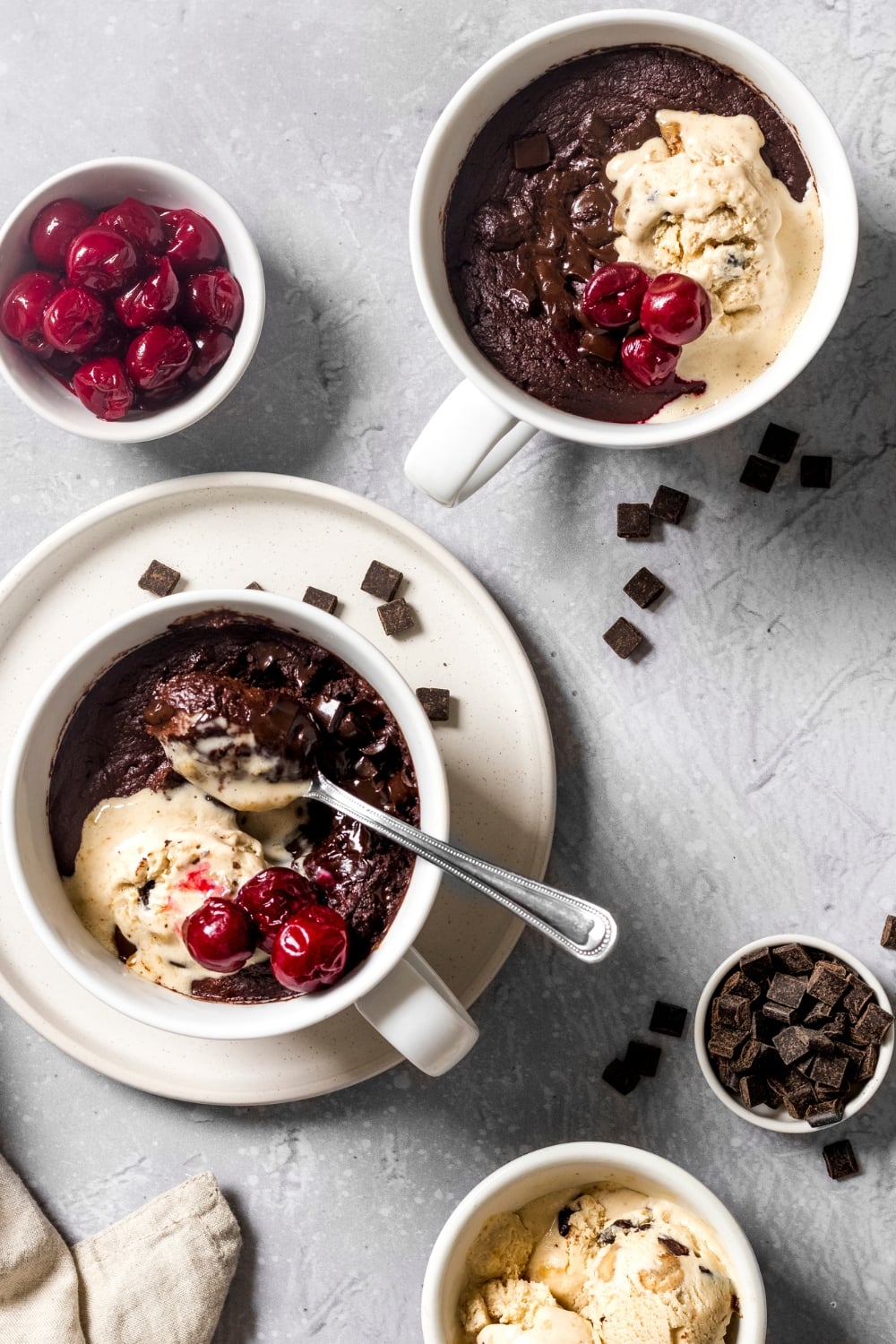 Top View of Chocolate Brownies in a Mug Topped With Cherries and Ice Cream
