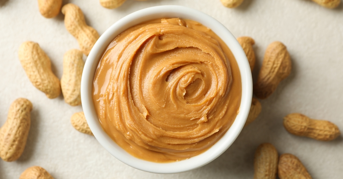 Homemade Peanut Butter in a White Bowl with Peanuts