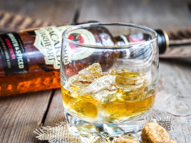 Iced Rum in a Glass, Bacardi bottle Lying on a Wooden Table