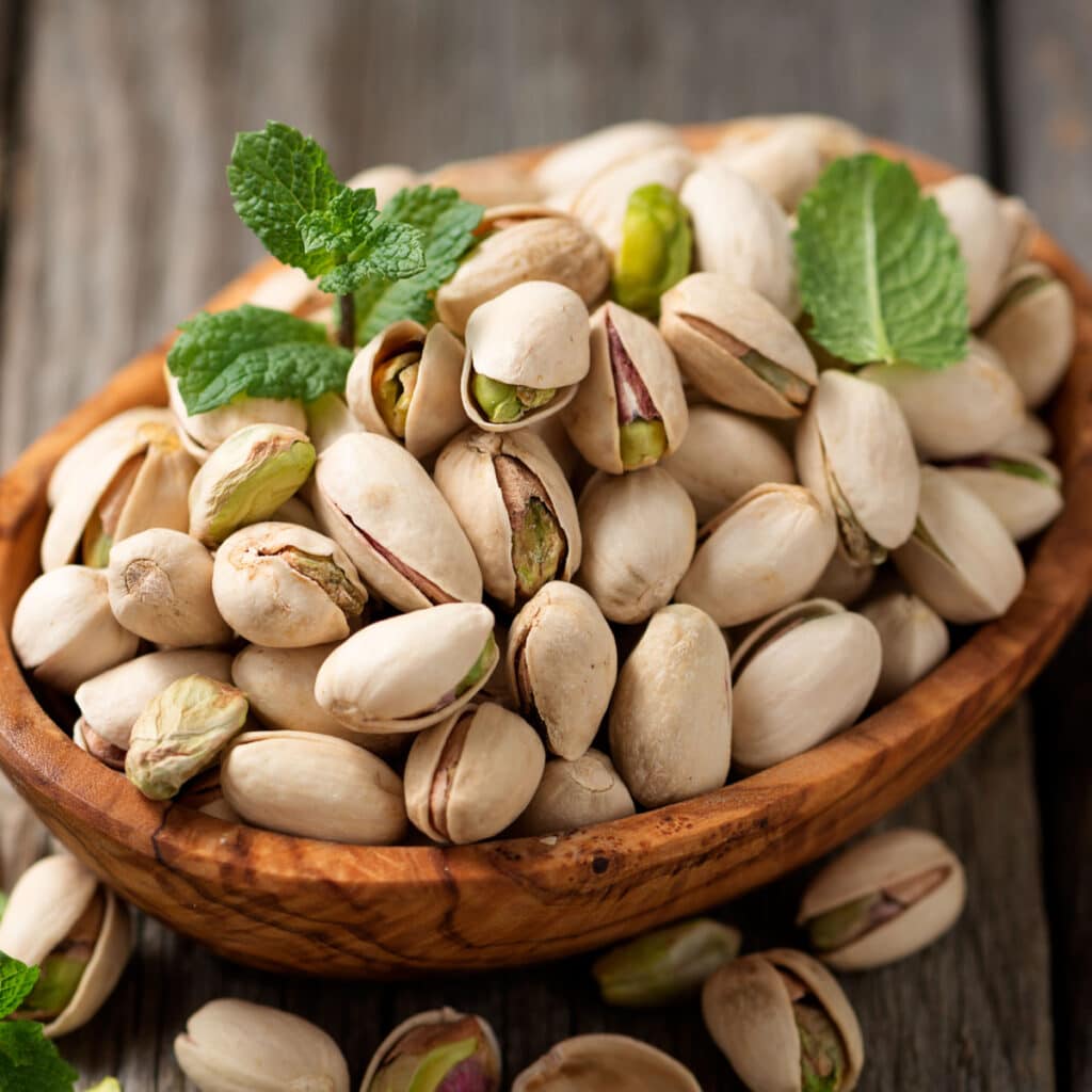 A Heap of Pistachios on a Wooden Bowl