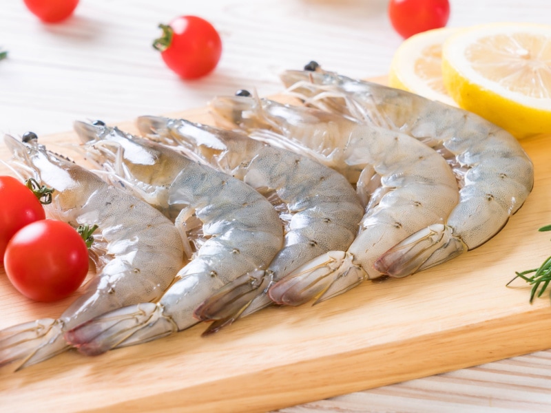 Five Pieces Raw Shrimp on a Wooden Cutting Board