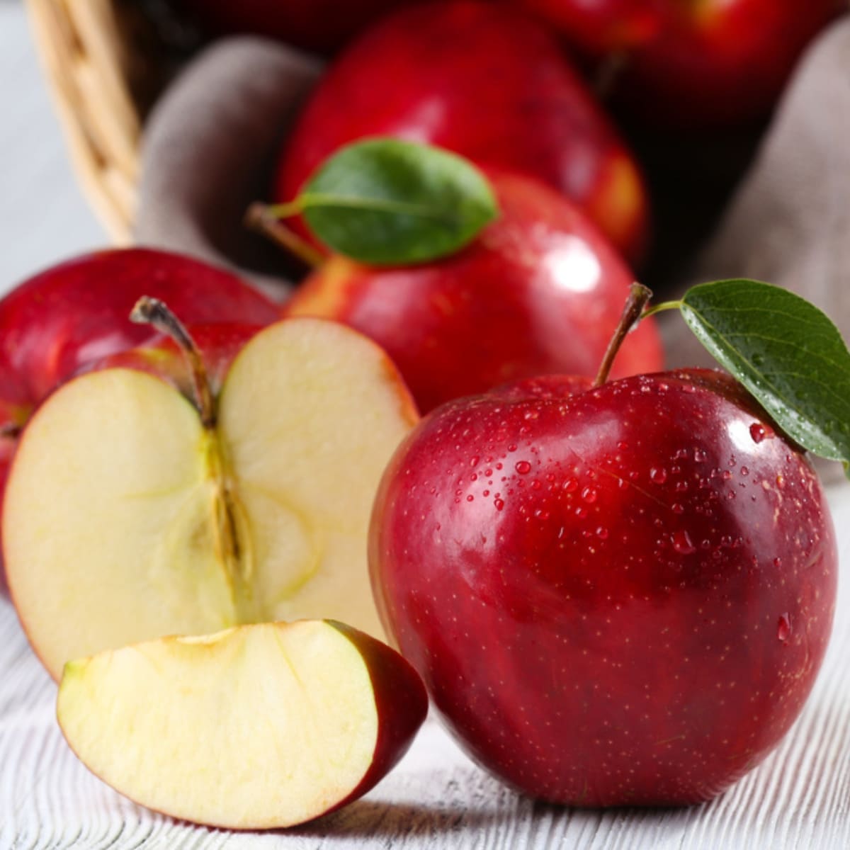 How to Freeze Apples: Dewy red apples on a wooden table