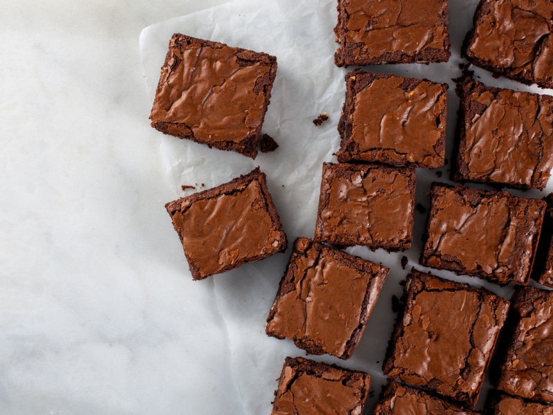 Sliced fresh baked crunchy and moist brownie on top of a baking sheet. 