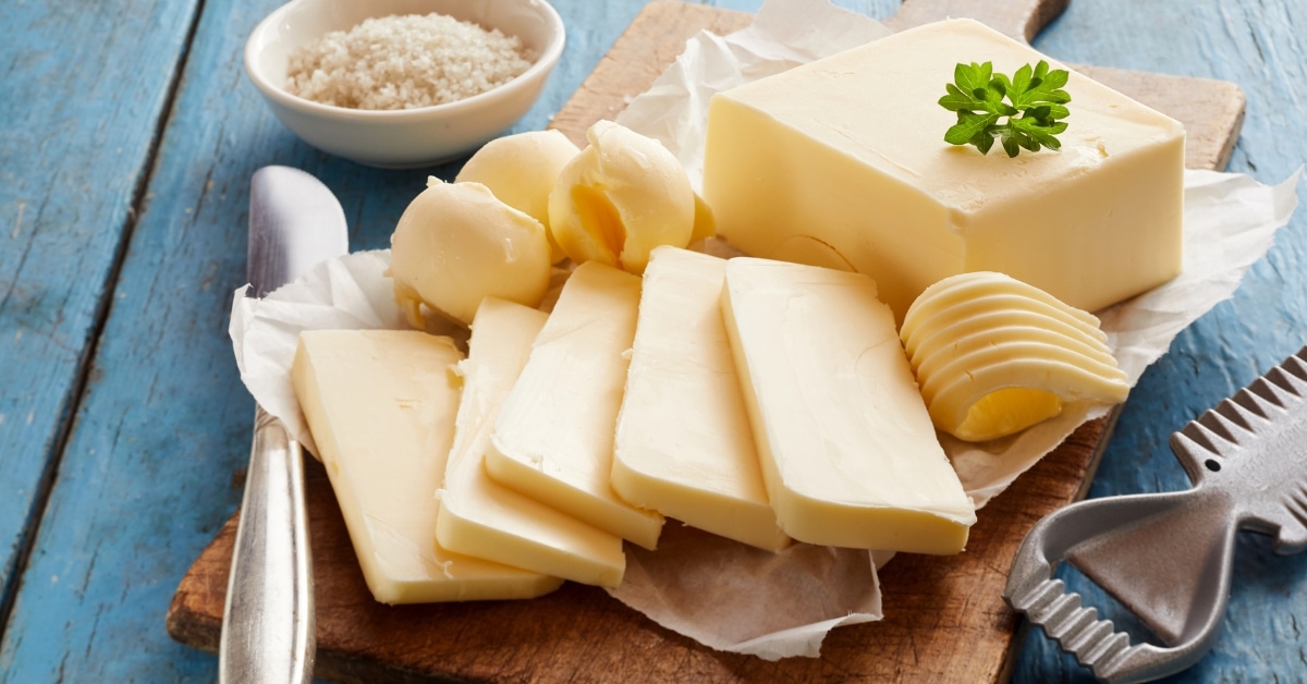 Whole Butter Sliced in a Wooden Cutting Board