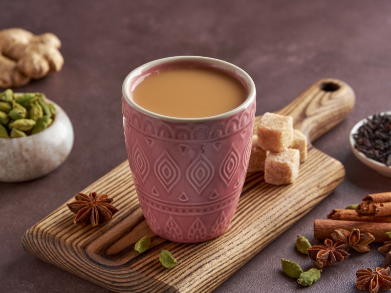 A Cup of Chai and Varieties Spices and Sugar on Wooden Board