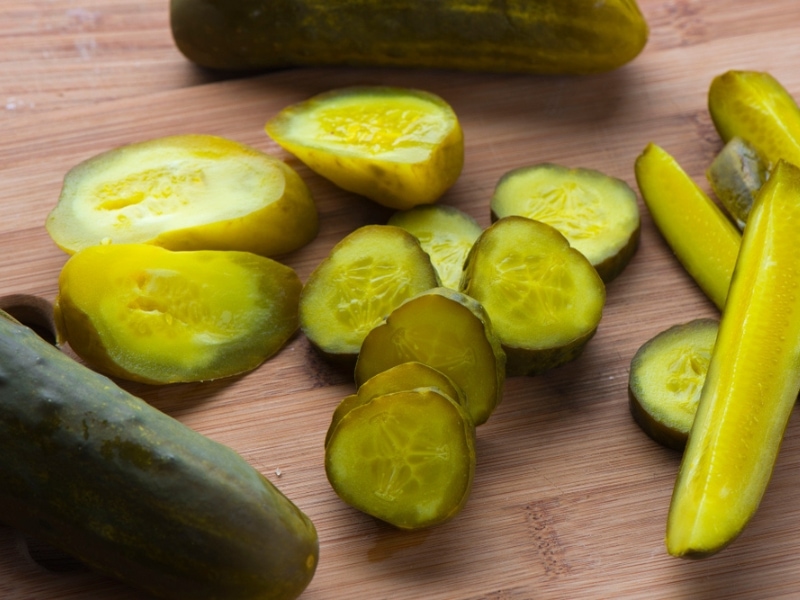 Sliced Kosher Pickles on A Wooden Cutting Board