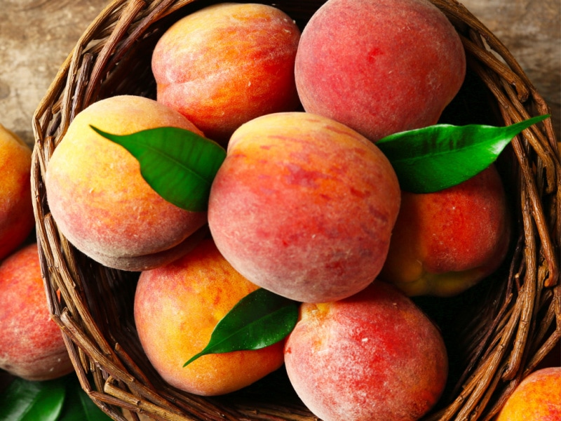 Bunch of Fresh Peaches on a Rattan Basket