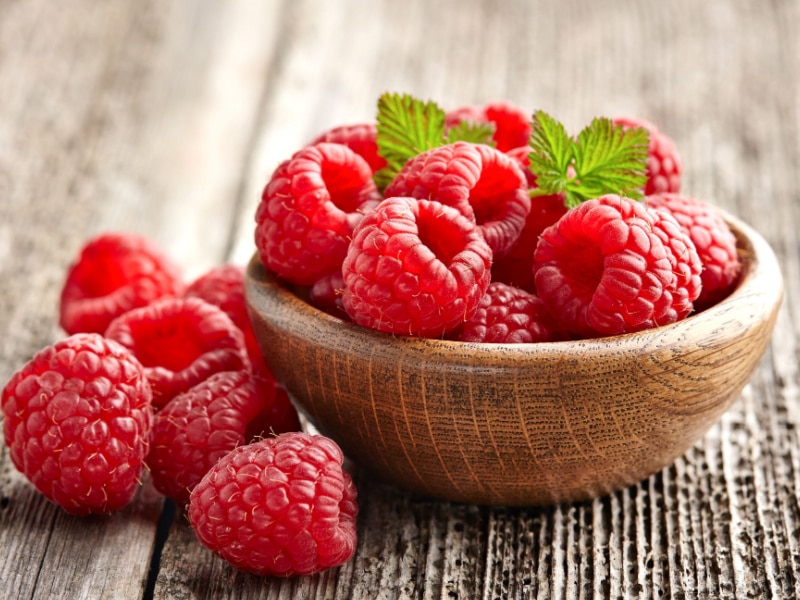 Bunch of Raspberries in a Round Wooden Bowl