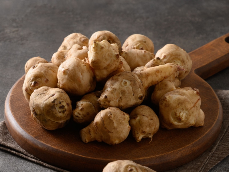 Bunch of Fresh Sunchokes on a Wooden Cutting Board