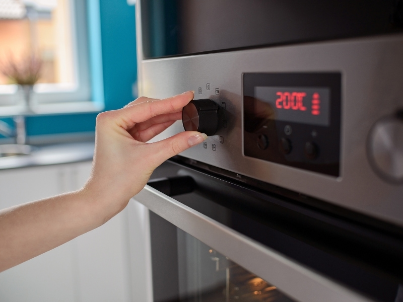 Woman Regulating Oven Temperature