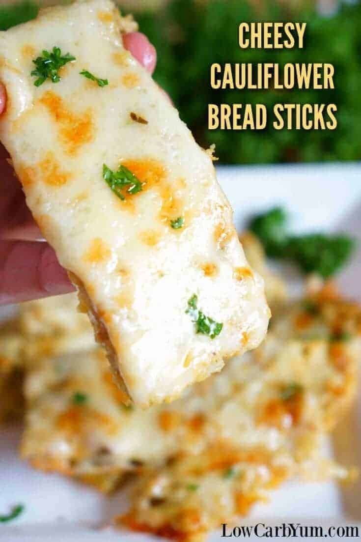 hand holding a cheesy keto cauliflower bread sticks.