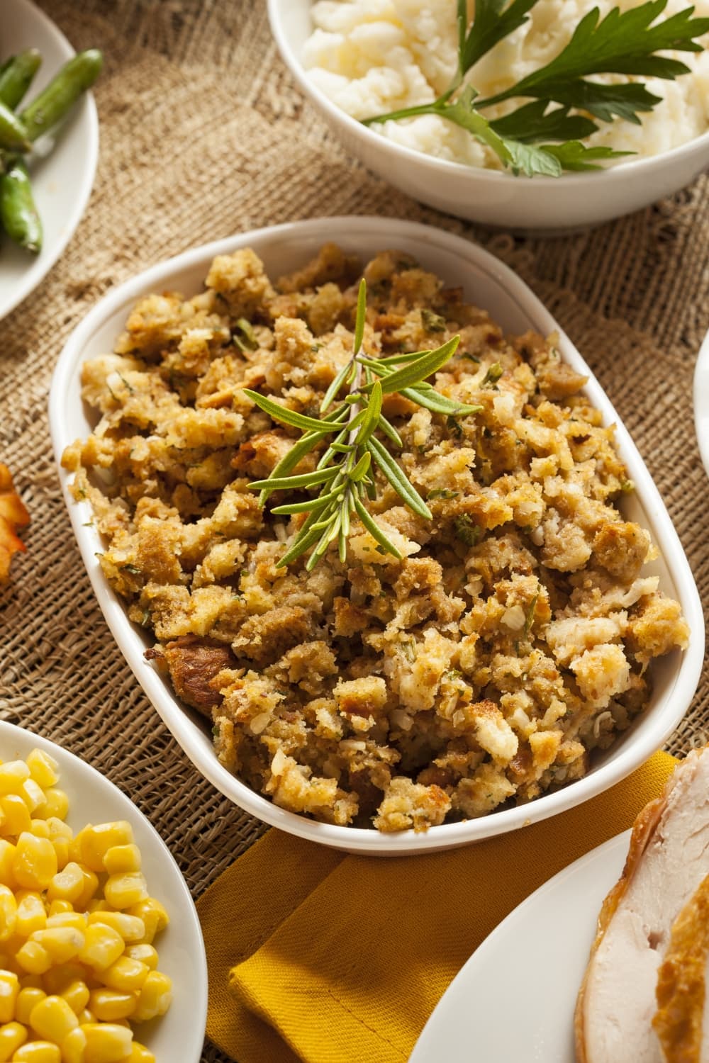 Paula Deen's Cornbread Dressing on a casserole with rosemary on top