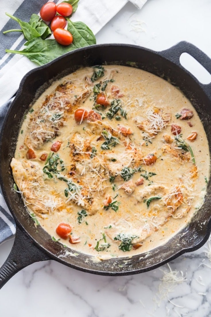 Spinach artichoke chicken casserole cooked in a skillet. 