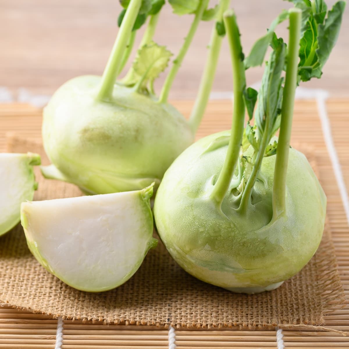 Sliced and Whole Fresh Kohlrabi on a Bamboo Mat