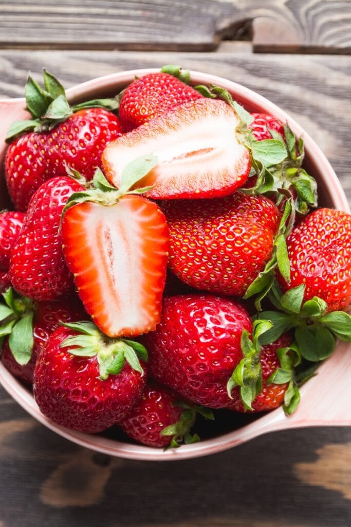 What Goes Well With Strawberries? (The Best Pairings) featuring Fresh Sliced and Whole Red Strawberries in a Bowl