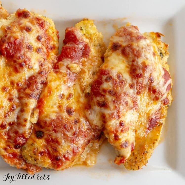 Chicken parmesan on a white plate. 