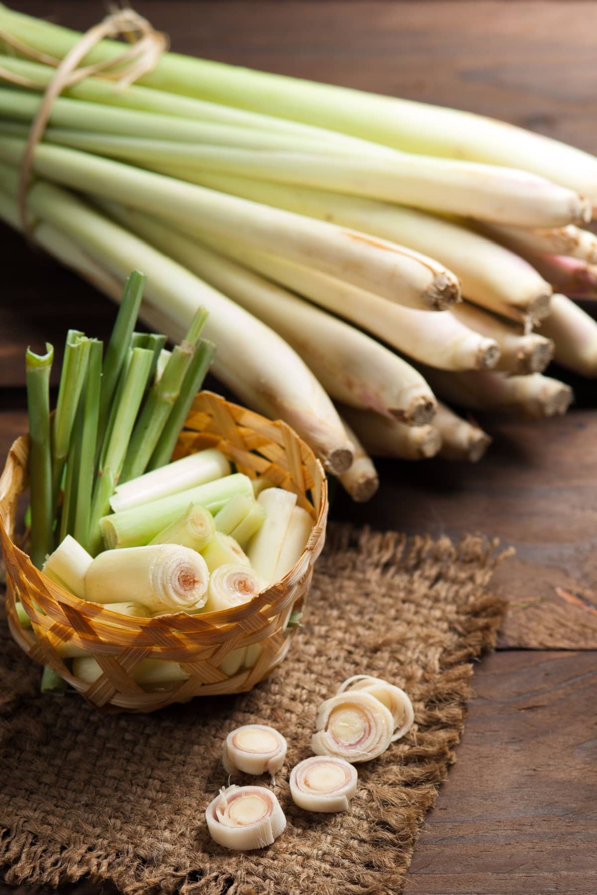 Chopped Lemon Grass on a Woven Basket and Whole Lemon Grass on a Wooden Table