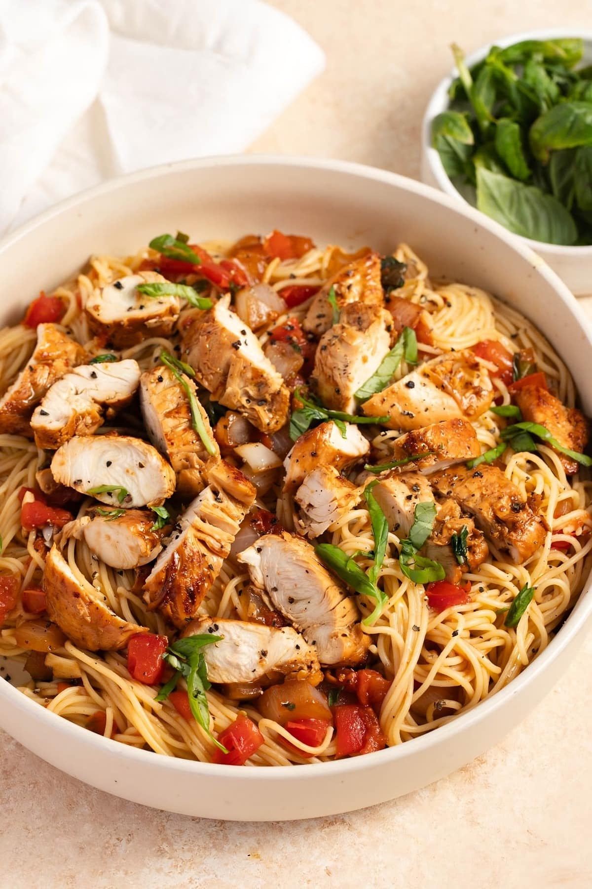 Bruschetta Chicken Pasta with Tomatoes and Herbs in a white bowl