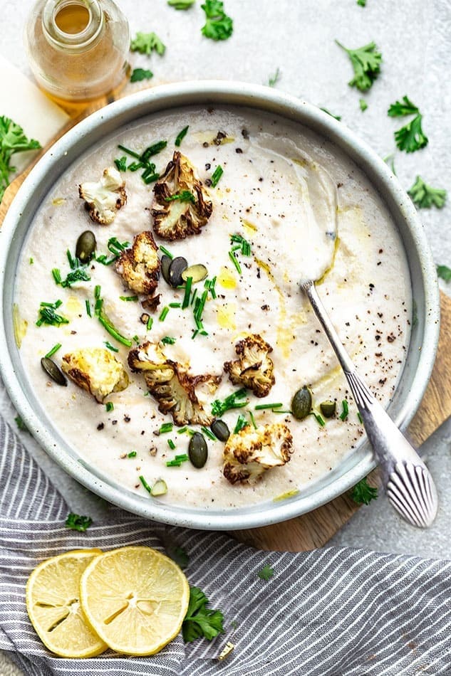 Bowl of vegan cauliflower soup with spoon. 