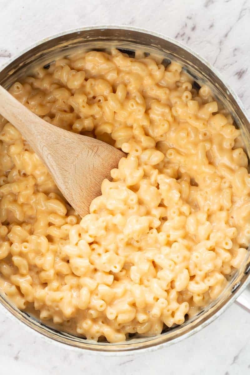 Keto Mac and Cheese on a pot mixed with a wooden ladle. 