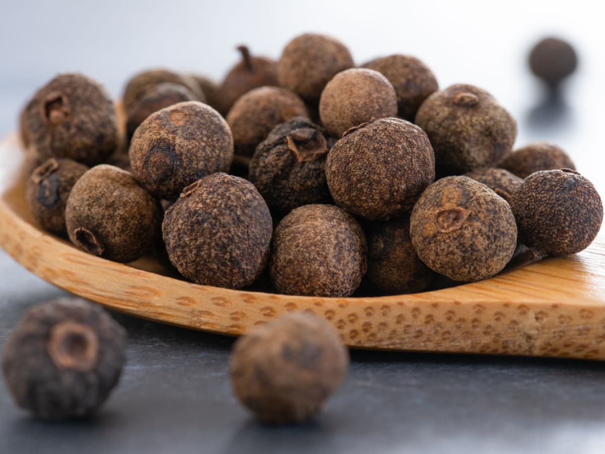 Organic Dry Allspice Berries on a Wooden Spoon