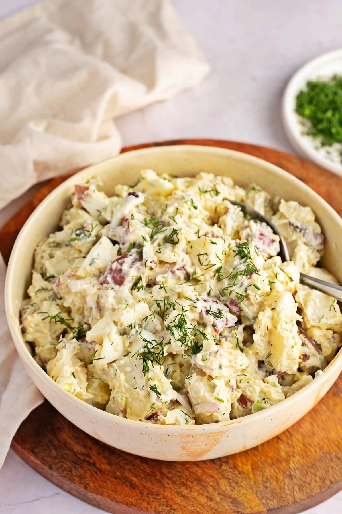 Homemade Creamy Red Potato Salad with Dill on a white bowl, 