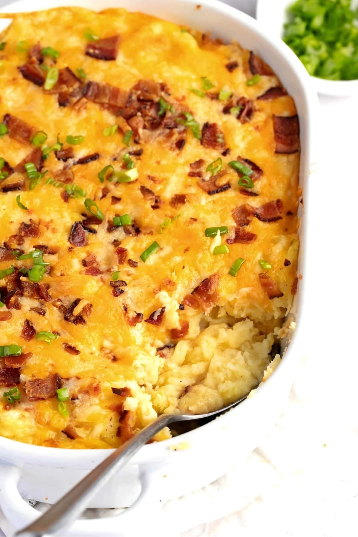 Loaded Mashed Potatoes with Bacon, Green Onions in a White Casserole