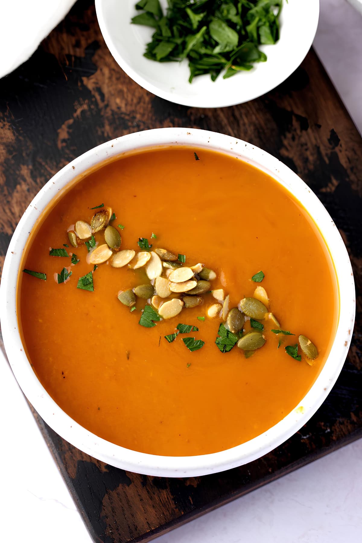 Bowl of Homemade Pumpkin Soup on a Wooden Board