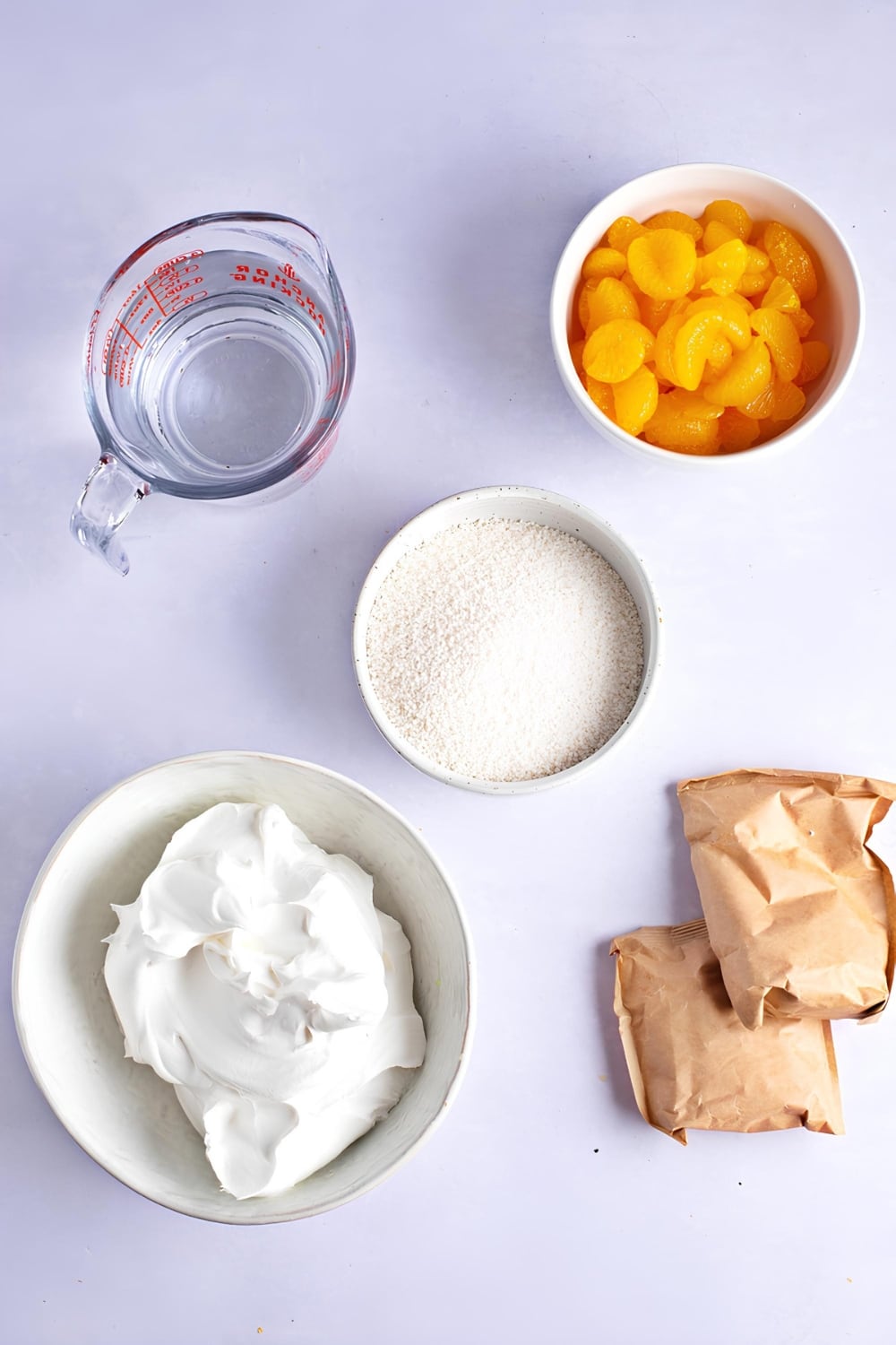 Orange Creamsicle Salad Ingredients, peeled mandarin orange slices, cool whip, tapioca pudding, packs of orange Jell-o, and water 