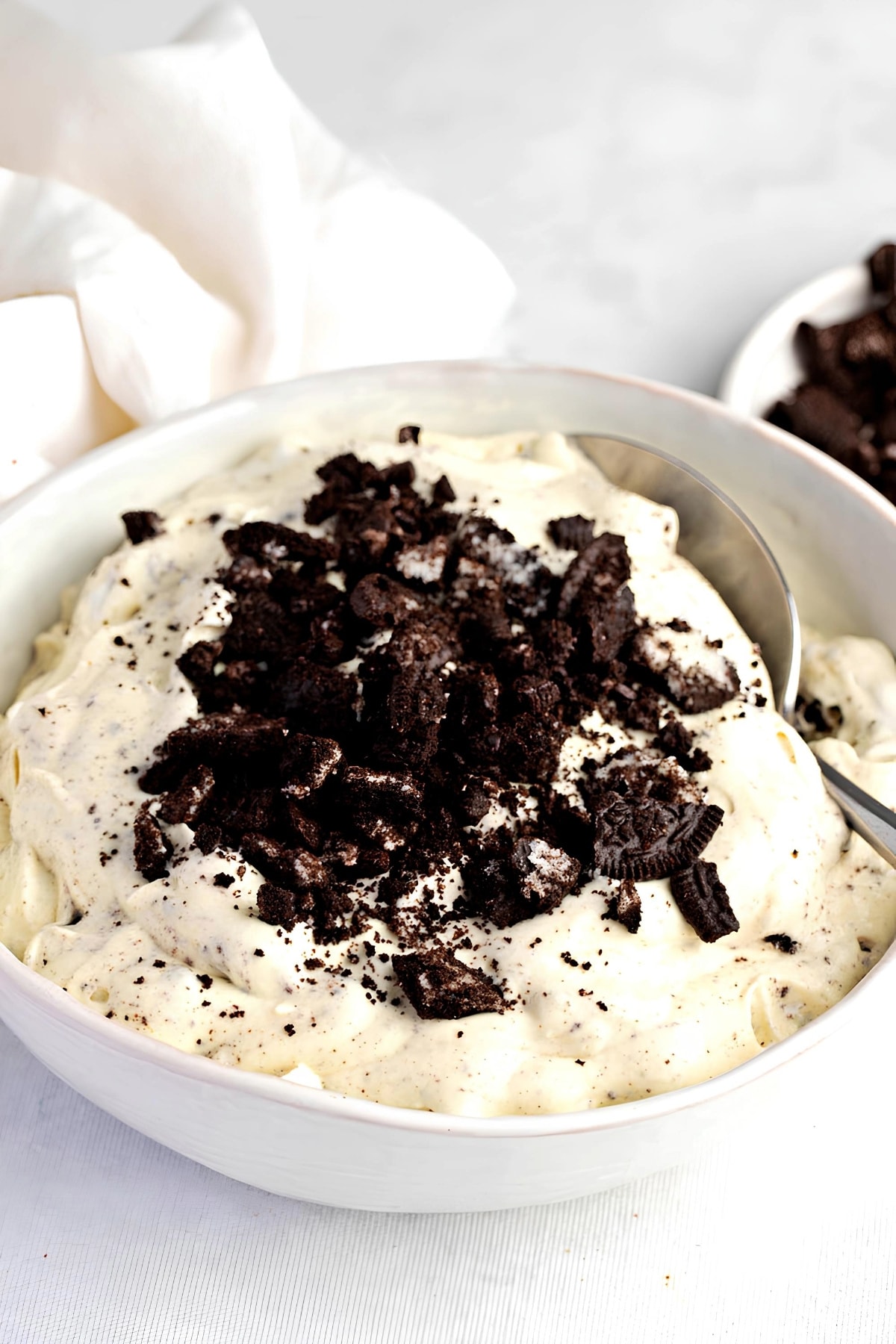 A bowl of creamy vanilla pudding, whipped cream, and crushed Oreos.