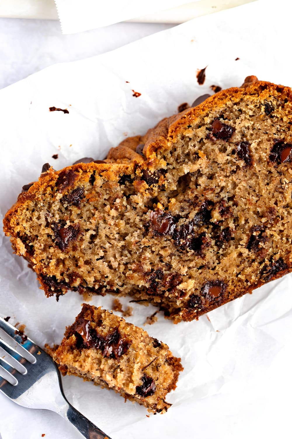 A slice of chocolate chip banana bread with a fork