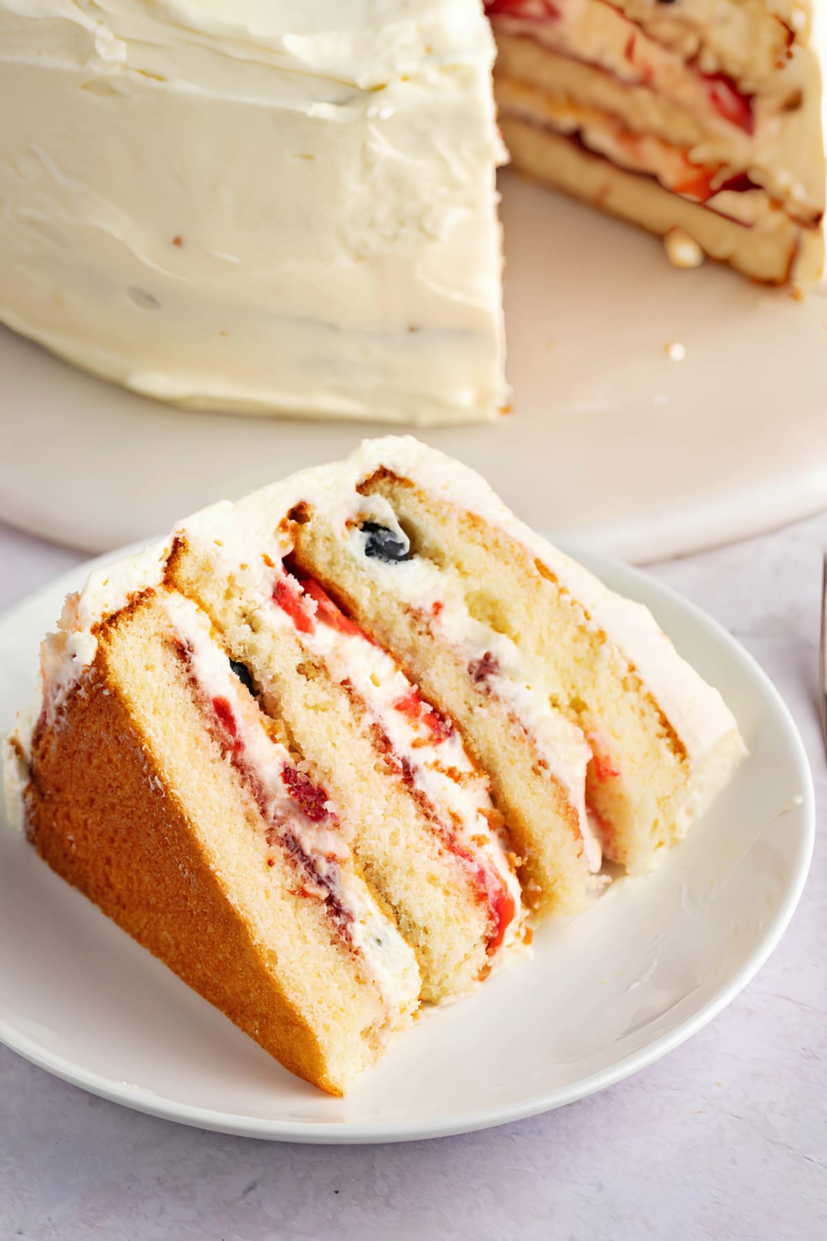 Sliced Homemade Chantilly Cake Filled with Strawberries and Blueberries